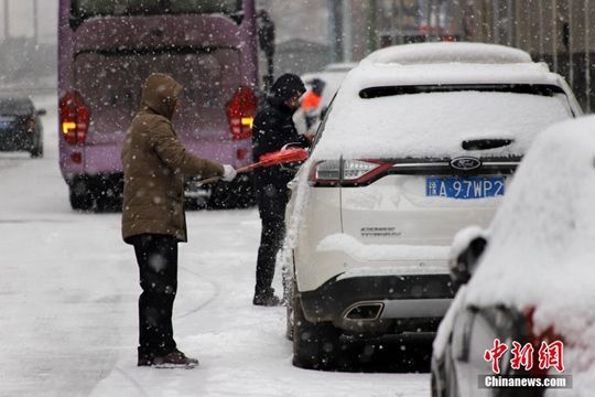 河南迎降雪天氣 民眾冒雪拎行李箱出行