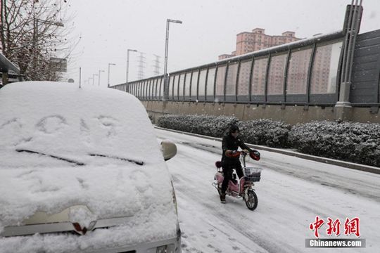 河南迎降雪天氣 民眾冒雪拎行李箱出行